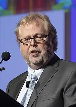 Myhrvold speaking into the microphone at a podium