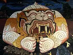 The mural painting at Wat Phra Kaew depicts a scene from the Ramakien, an epic Thai poem, where Hanuman expands his gigantic body to protect Phra Ram's tabernacle.