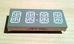 A four-character 14-segment clock display. Note unbroken top and bottom segments in comparison with a sixteen-segment display.
