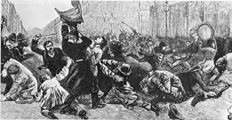 A depiction of a dense crowd being physically subdued by police in the street. Tall buildings are in the backround. In the forground, an officer in a long tunic and helmet wrestles a flag from a woman while men are on their knees shielding themselves from blows. Above them, a man raises a stick to strike someone. Other truncheons and sticks can be seen raised in background. To the right of the picture, people can be seen running away from police, two men carry a large marching drum above their heads as they do so.