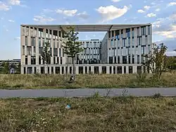 Elaborate modern building from behind a grass-surrounded path