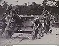 Flatcars being used to transport an Australian Ordnance QF 25-pounder Short in Seria, 1945.