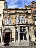 Terraced building with LGBTQ+ flags and sign 'Mary's'