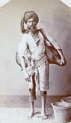 Photograph of a male water carrier in a turban