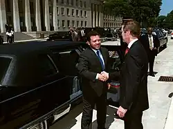 Abdullah shaking hands with former US defense secretary William Cohen outside a limousine