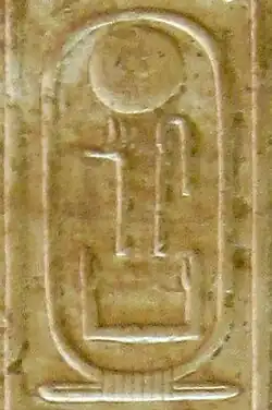 Hieroglyphic inscription on yellowish stone showing an oval cartouche with signs inside