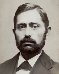 A short-bearded man in a suit