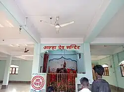Two young people looking at an indoor shrine