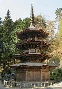 Wooden three-storied pagoda with octagonal floor plan and an additional enclosing pent roof.