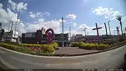 alt:A park with the sculpture of a symbol of Venus surrounded by several crosses.