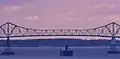 A cargo ship passing under the bridge