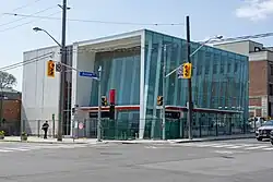 A photo of the largely completed secondary entrance to Avenue station. It is a modern, white building with glass panelling.