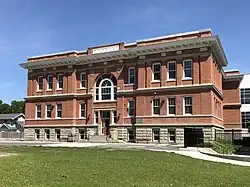 A 2-story, red brick school with a central door and "A.D. 1909" engraved across the top.