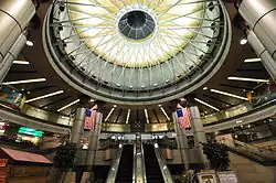 A multi-story rotunda with steel columns and a large round skylight