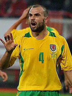 A man wearing a yellow and green football shirt.