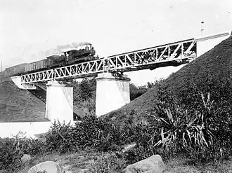 A NIS 3XX (now known as C 20 XX) with NS 2XX (now known as C 16 XX) crosses a railway bridge over the Code River (pronounced: [tʃo:ɖe]) in Yogyakarta on the line between Semarang to the "Vorstenlanden" or Royal Lands of the Surakarta Sunanate and the Sultanate of Jogjakarta