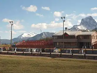 A biathlon stadium with mountains in the background.