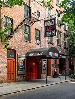 Exterior of a red brick theater with a black awning and banner, which both read, "Cherry Lane Theatre" in white and red text