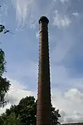 The 120-foot (37&nbsp;m) tall chimney, brick with oversailing caps