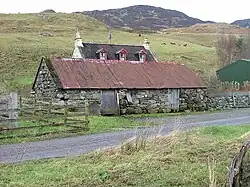 Croft in Upper Ardelve, a Highland settlement on Loch Alsh (2007). Image shows farmhouse behind a modest livestock shed. Cows graze the rear fields.