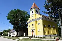 Village hall and Roman Catholic church on Main Street Csém