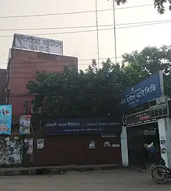 An unremarkable building with a small gate offset on the road