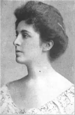 20th-century B&W portrait photo of a young white woman with dark hair in an up-do, wearing a pale blouse