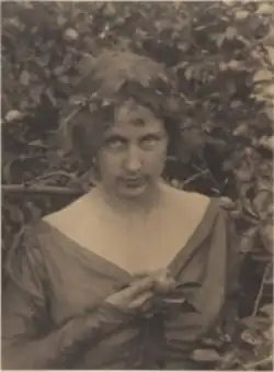 20th-century B&W portrait photo of a young woman wearing a dark dress.