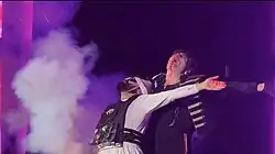 The Pierrot and an un-dead Gerard Way, still in-costume, hold each other before the Pierrot's bomb vest explodes and closes the first set.