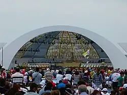 A crowd of people face a domed room