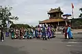 People in formal mandarin official uniforms walking in a parade.