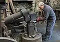 Demonstrating the flattening of a red hot cast iron bar using the tilt hammer