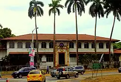 Former YMCA building in Panama Canal Zone, a gold and white building, now fenced off from the public.