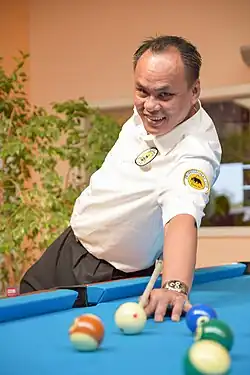 Francisco Bustamante playing an exhibition shot with the cue behind his back