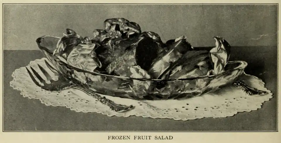1915 Frozen Fruit Salad, served on a lettuce leaf. The method of preparation is described in the footnotes:[b]