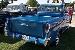 Rear view of a medium blue colored pickup truck