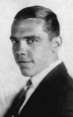 Black and white portrait photograph of Rockwell wearing a suit