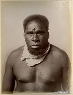 Portrait photograph of a shirtless Aboriginal man