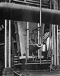End view of water jacket furnace. Molten copper matte flowed through the spout shown, into a settler, and then into a ladle to be carried to the converter by a gantry crane. c.1908