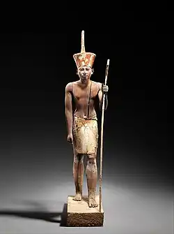 A guardian statue wearing the red crown which reflected the facial features of the reigning king, probably Amenemhat II or Senwosret II, and which functioned as a divine guardian for the imiut; made of cedar wood and plaster 1919–1885 BC