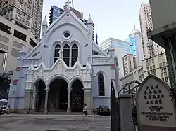The façade of a Gothic Revival cathedral with flanking flying buttress on both sides
