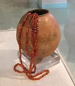 Burnished and Painted Clay Ovoid Vase depicting horned figure, with Round Carnelian Beads in, Burzahom (Kashmir), 2700 BC
