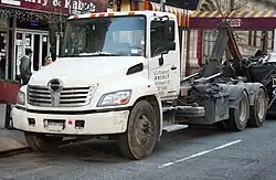 Hino 338 hook truck with an aftermarket pusher axle