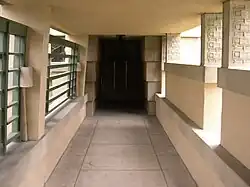 The entrance loggia on the north side of the house. There are metal grilles on the left and half-height partitions on the right.
