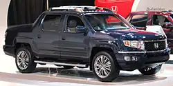 2011 Ridgeline EX–L with OEM accessory sport grill, chrome bumper trim, chrome side steps, body side protectors, taillight garnish, roof rack, and aftermarket rims (Canadian model)