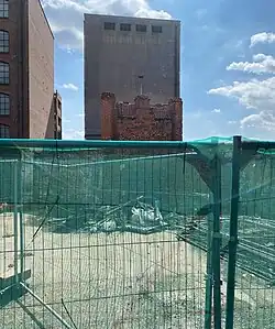 The reverse of Wolsey's Gate, showing temporary fencing and rubbish