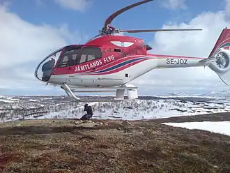 A Eurocopter EC-120 helicopter – the rotor blades seem to be swept back more than usual due to the rolling-shutter effect.