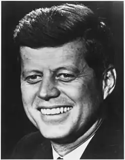 Black-and-white head shot of Kennedy smiling
