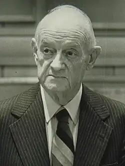 A picture of newspaper publisher John S. Knight, holding a folded up newspaper under his left armpit