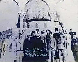 This picture refers to the visit of King Abdullah I, King of the Hashemite Kingdom of Jordan, to Al-Aqsa Mosque and the Dome of the Rock in Jerusalem in 1947 CE. He was received by everyone who came down the steps of the scales to visit the blessed Al-Aqsa Mosque. In the middle of the picture is His Majesty King Abdullah I, and to his right is Sheikh Yousef Tahboub al-Marwani, senior member of the Supreme Muslim Council in Palestine, receiving the King
